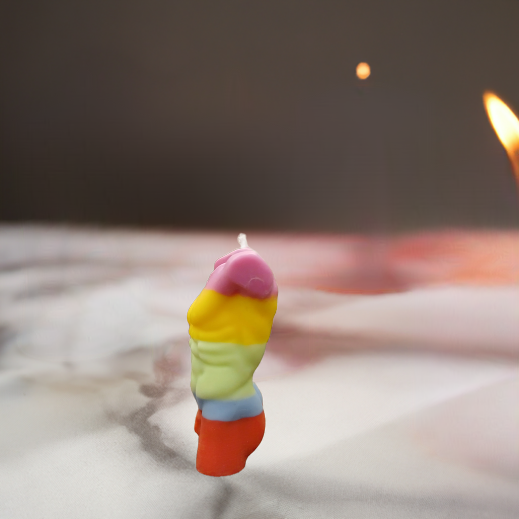 A striking LGBTQ+ male figure candle from Scent   Fushion Candles, with vibrant color-poured wax in a bold rainbow pattern, representing diversity and unity in a decorative piece."